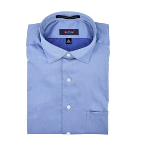 Folded light blue dress shirt with a brand label on a white background