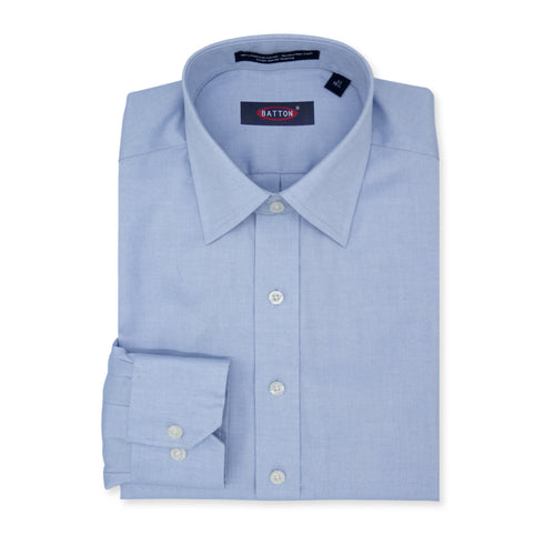 Folded light blue dress shirt with a visible brand label on a white background