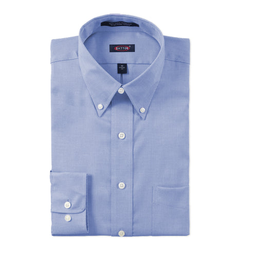 Folded light blue dress shirt with button details on a white background