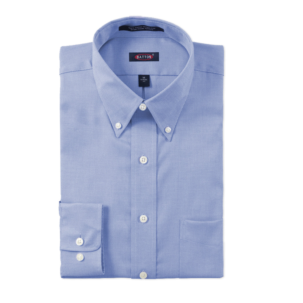 Folded light blue dress shirt with button details on a white background
